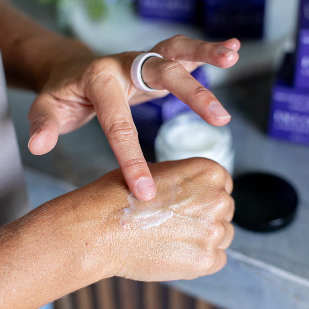Woman applying Lavender & Santal tallow face cream to hand
