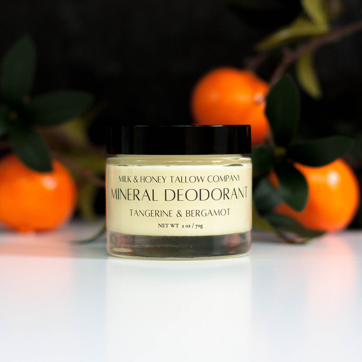 Jar of Tangerine and Bergamot Mineral Deodorant with tangerines in the background