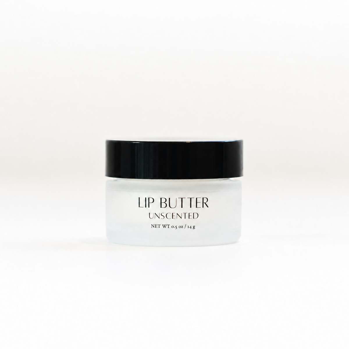 A small frosted glass jar of unscented lip butter with a black lid, centered on a clean white background.
