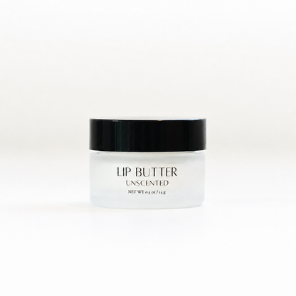 A small frosted glass jar of unscented lip butter with a black lid, centered on a clean white background.