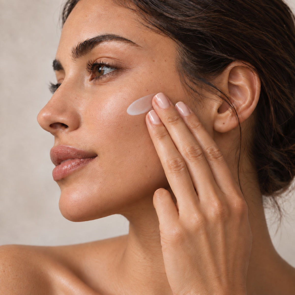 Woman applying tallow face cream to her cheek