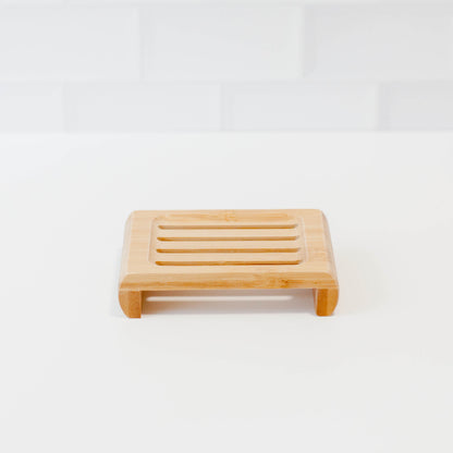 Bamboo soap stands on white counter with white tile backsplash