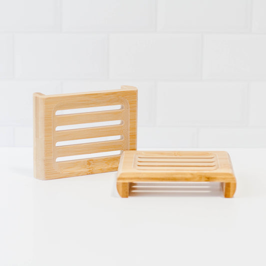 Bamboo soap stands on white counter with white tile backsplash