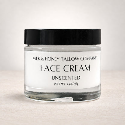 Glass jar of unscented tallow face cream on a white background