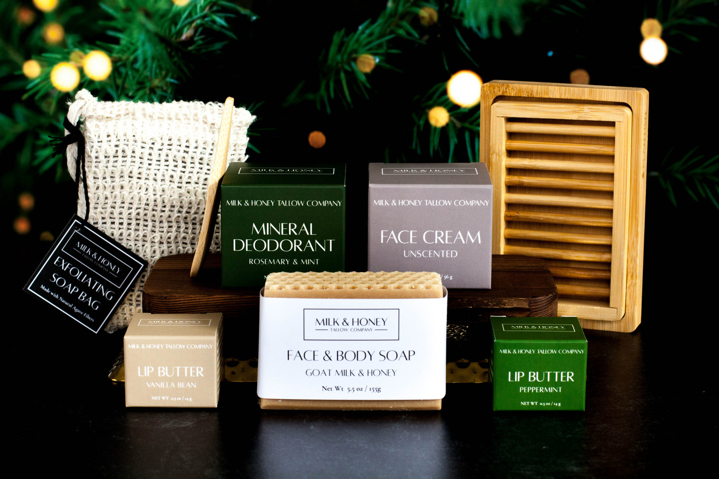 Collection of natural tallow skincare and body care products with a dark background and Christmas lights.