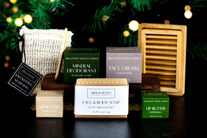 Collection of natural tallow skincare and body care products with a dark background and Christmas lights.